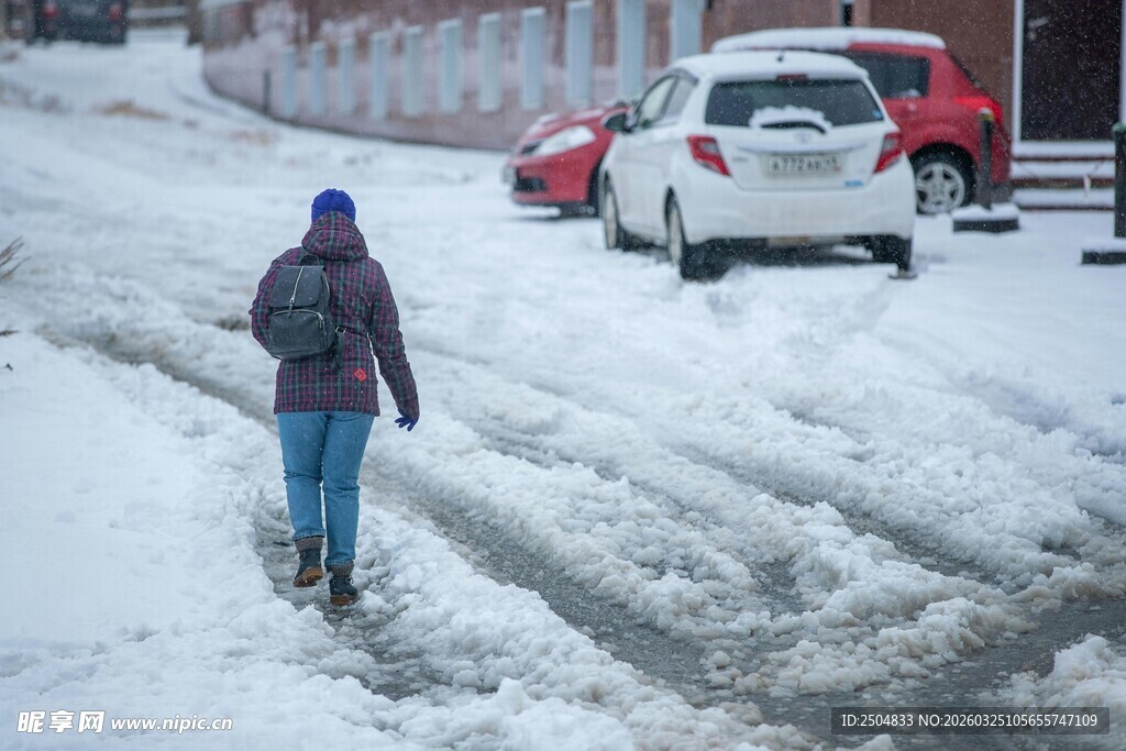 雪中行人与停放的车辆