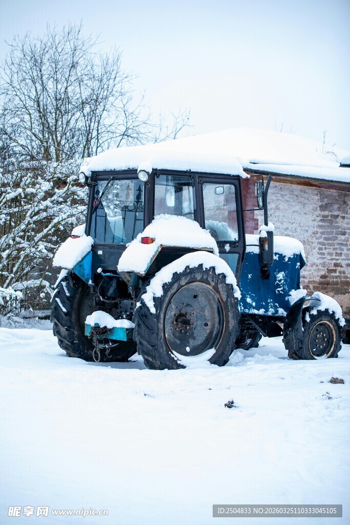 雪后停在户外的蓝色拖 机