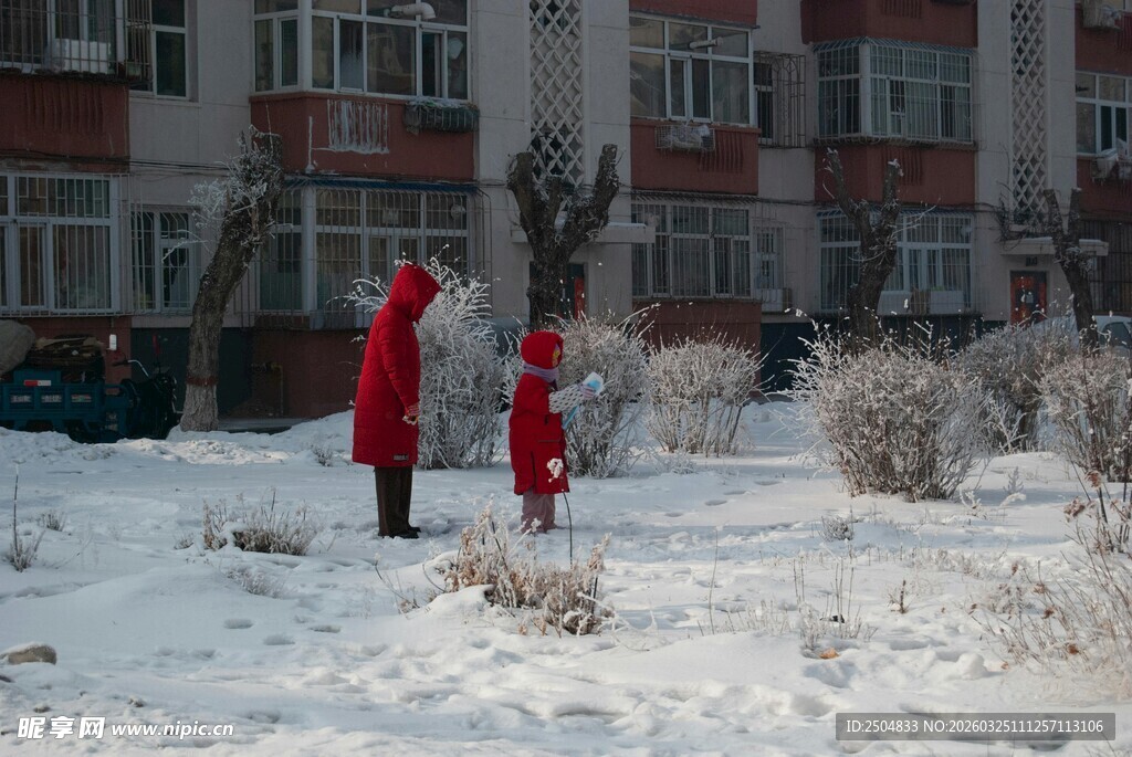 雪地中身着红衣的亲子互动