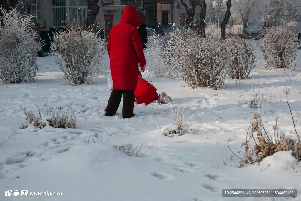 红衣人雪地中带娃玩耍