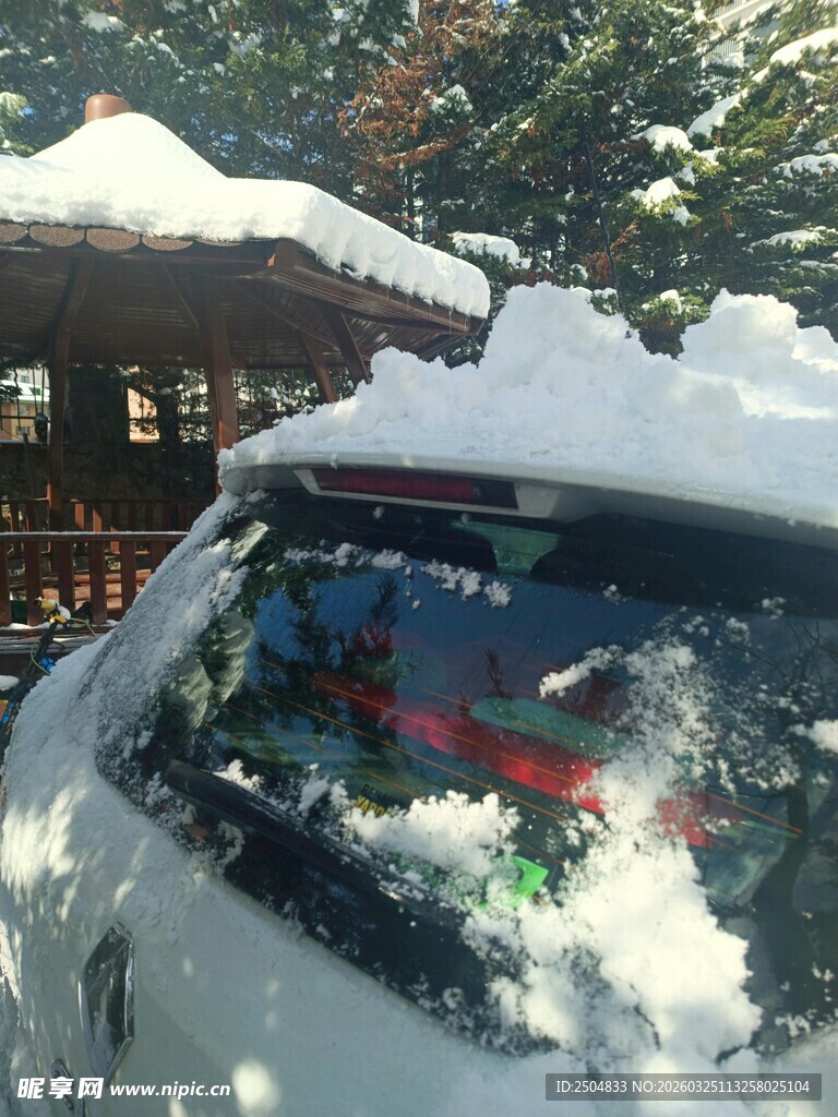 车顶积雪的车辆与木屋