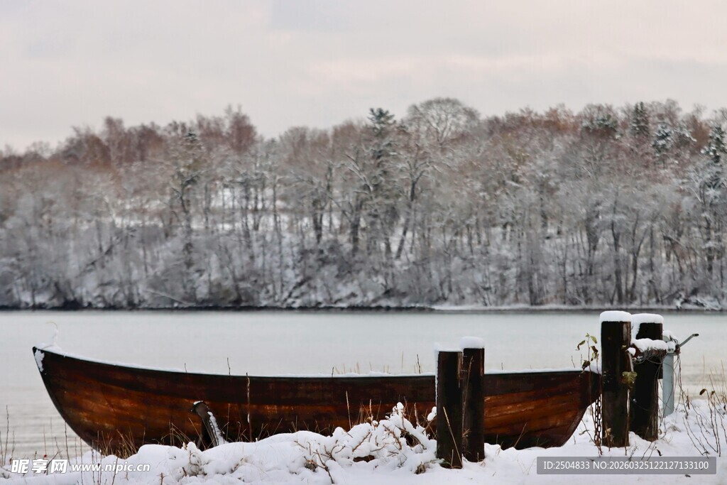 雪覆湖面的老旧船只