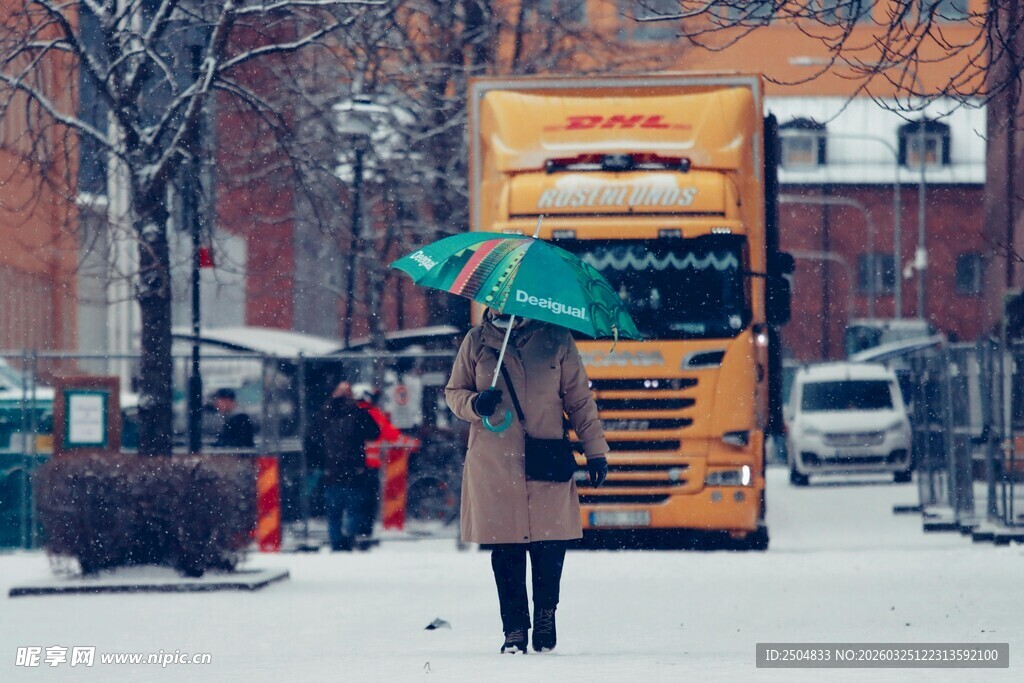 雪中撑伞女子与黄色车辆