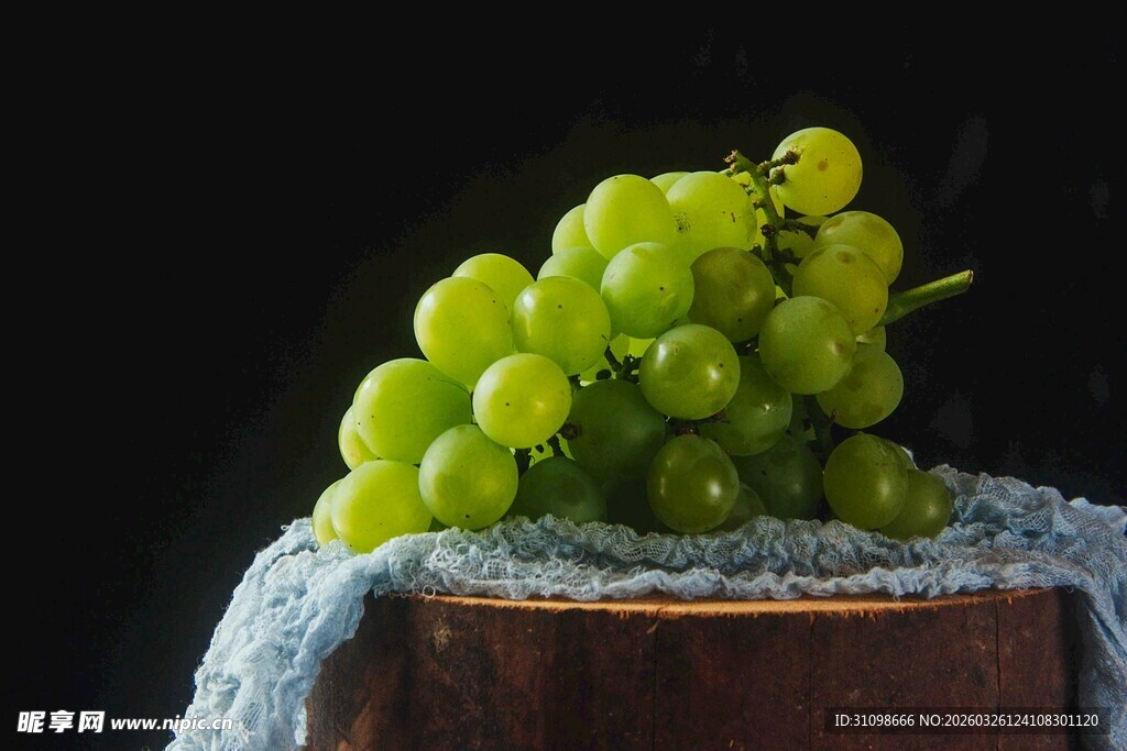 青葡萄置于布面木台上