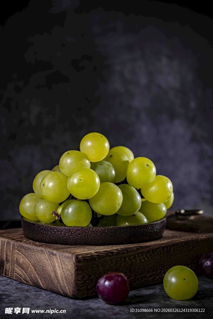 绿葡萄堆叠在木盘上