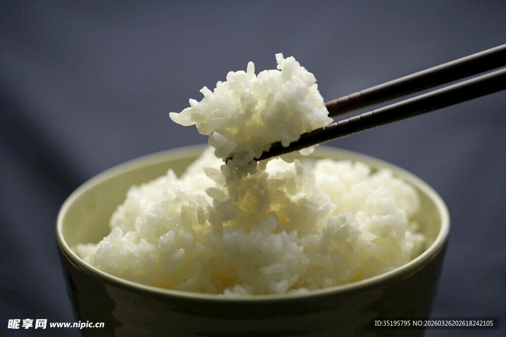 筷子夹起的一碗白米饭