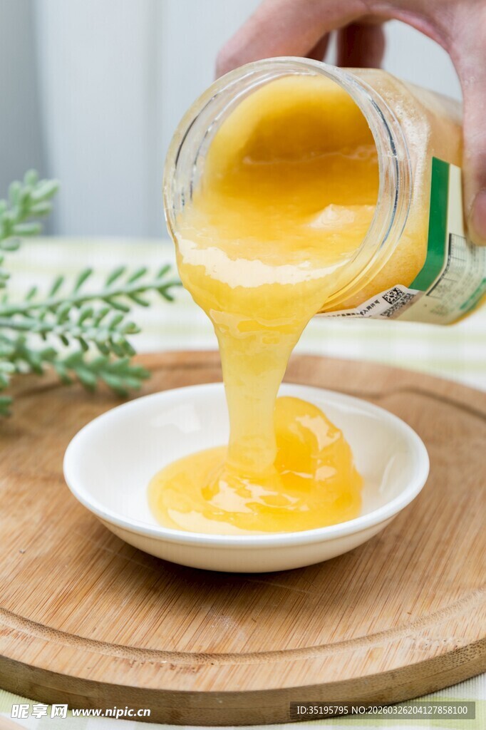 蜂蜜正从罐中倒入盘中