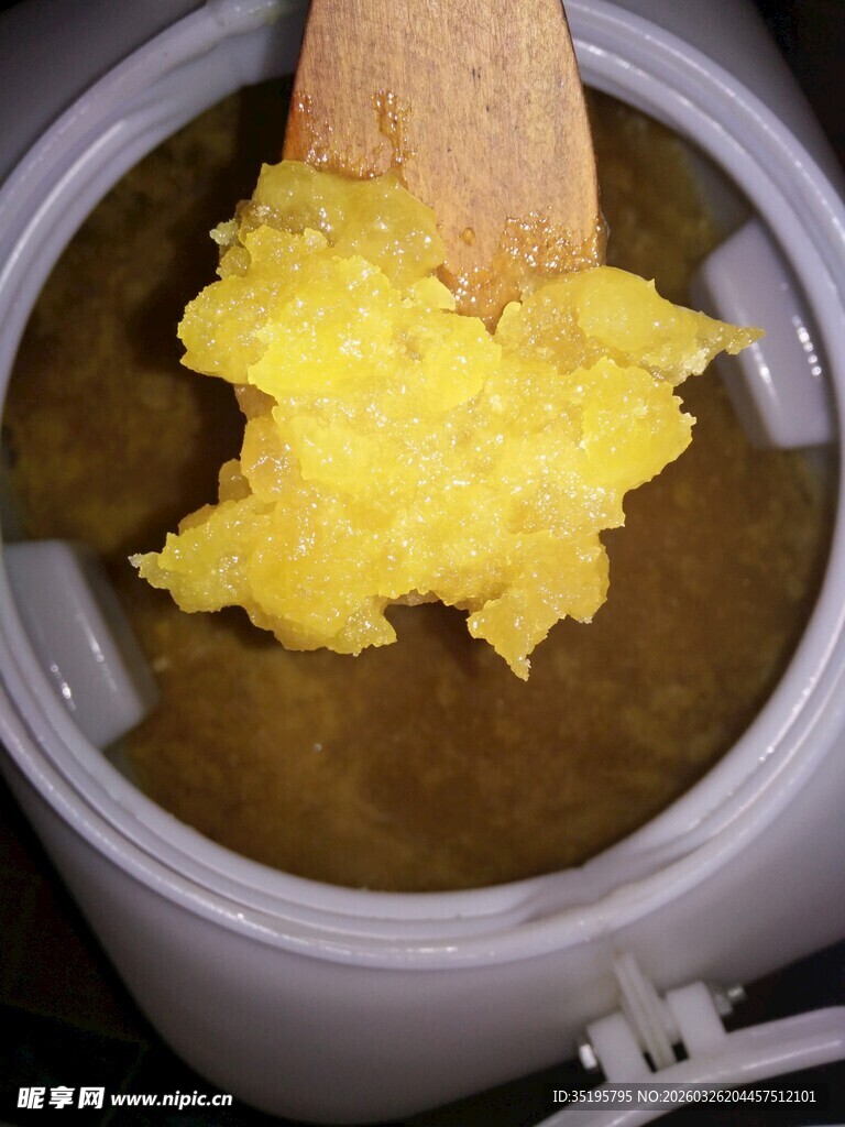 锅中木勺搅拌黄色糊状食物