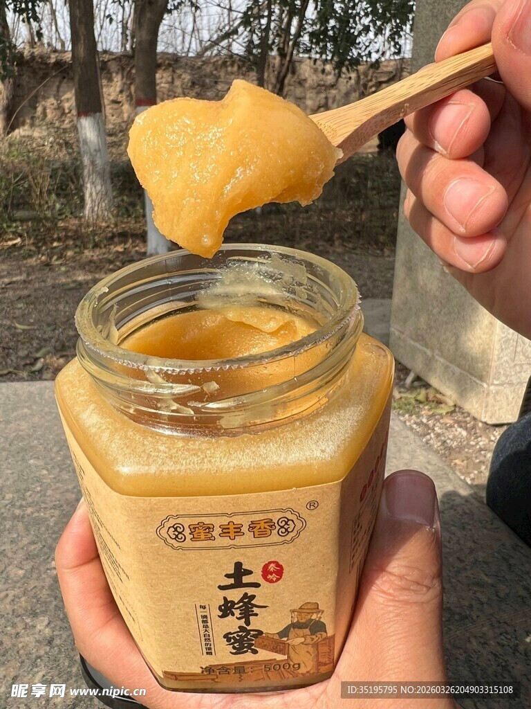 手持蜂蜜罐展示天然蜂蜜