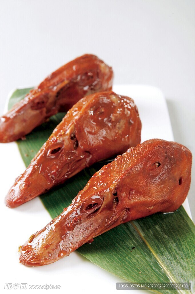 美味卤鸭头摆于绿叶上
