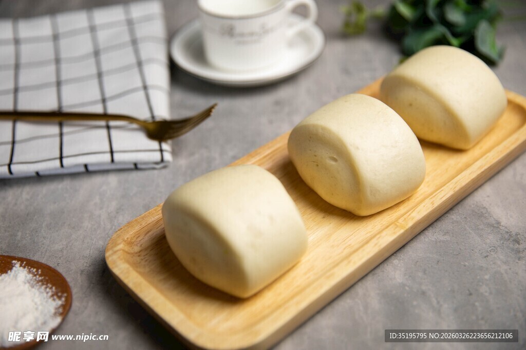 木制托盘上的三个白馒头