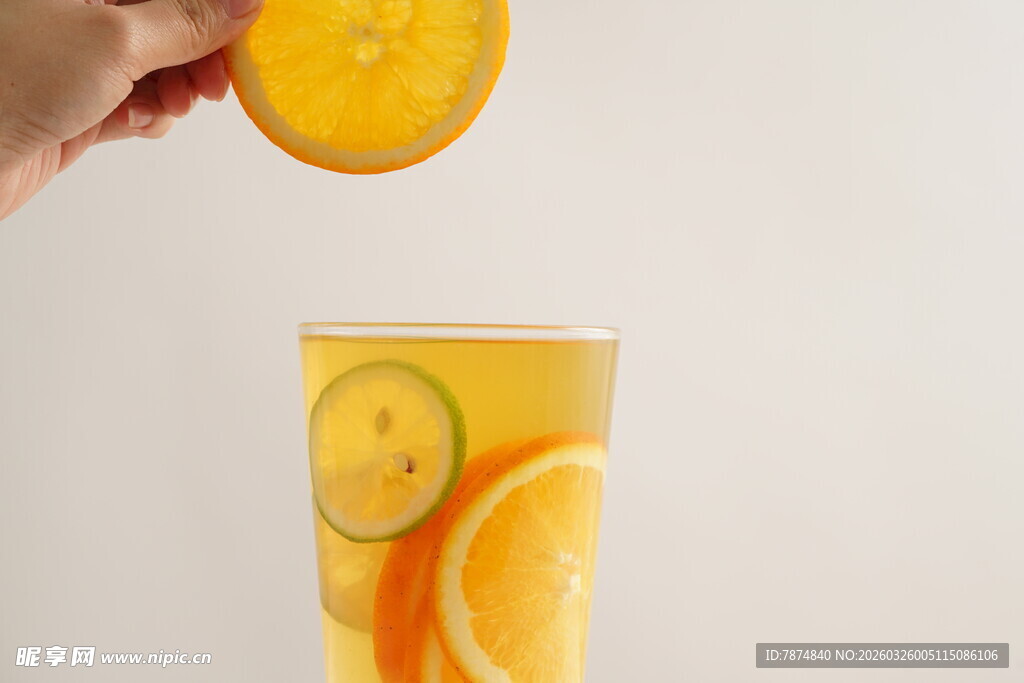 橙子片落入满杯果汁中