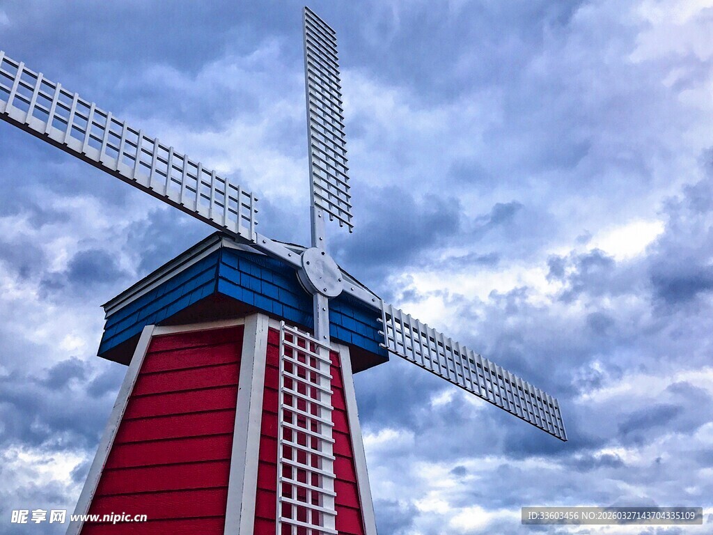 红色风车立于蓝天白云下