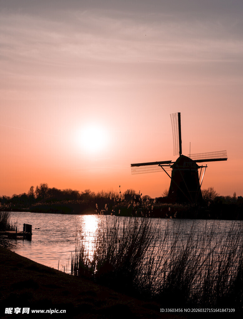 夕阳下的风车与宁静水面