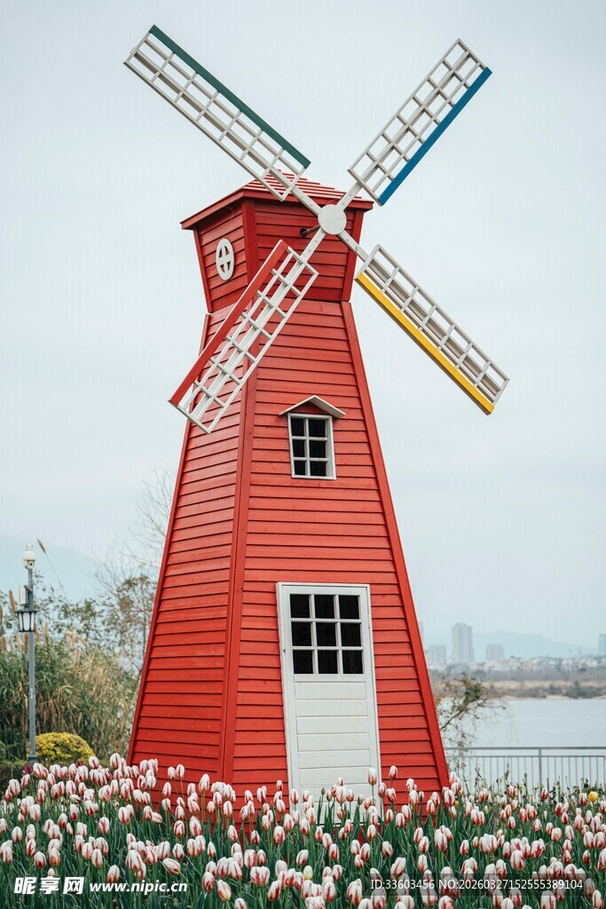 红色风车旁的缤纷花卉