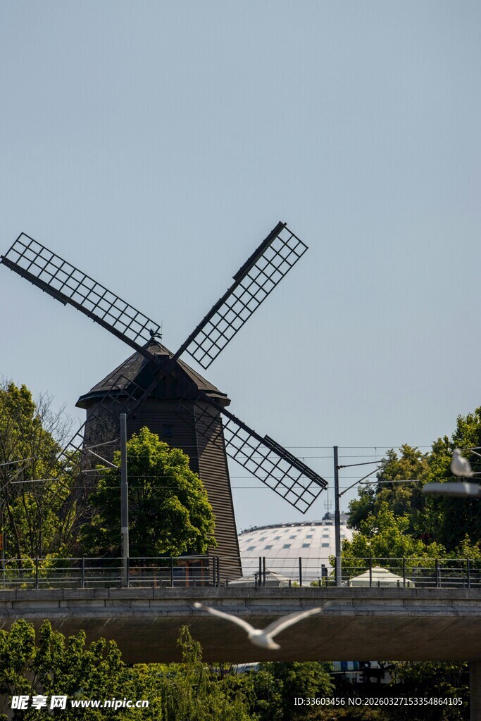古老风车屹立于绿荫间