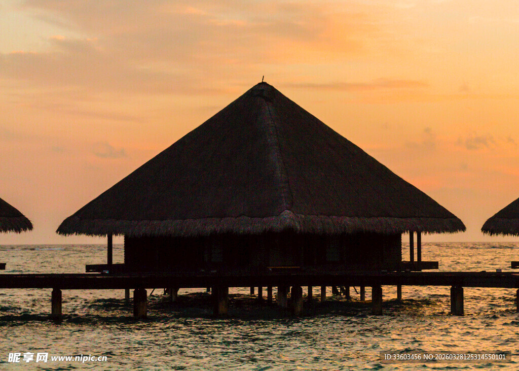 夕阳下的水上茅草屋