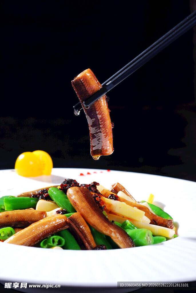 筷子夹起美味鳝鱼菜肴