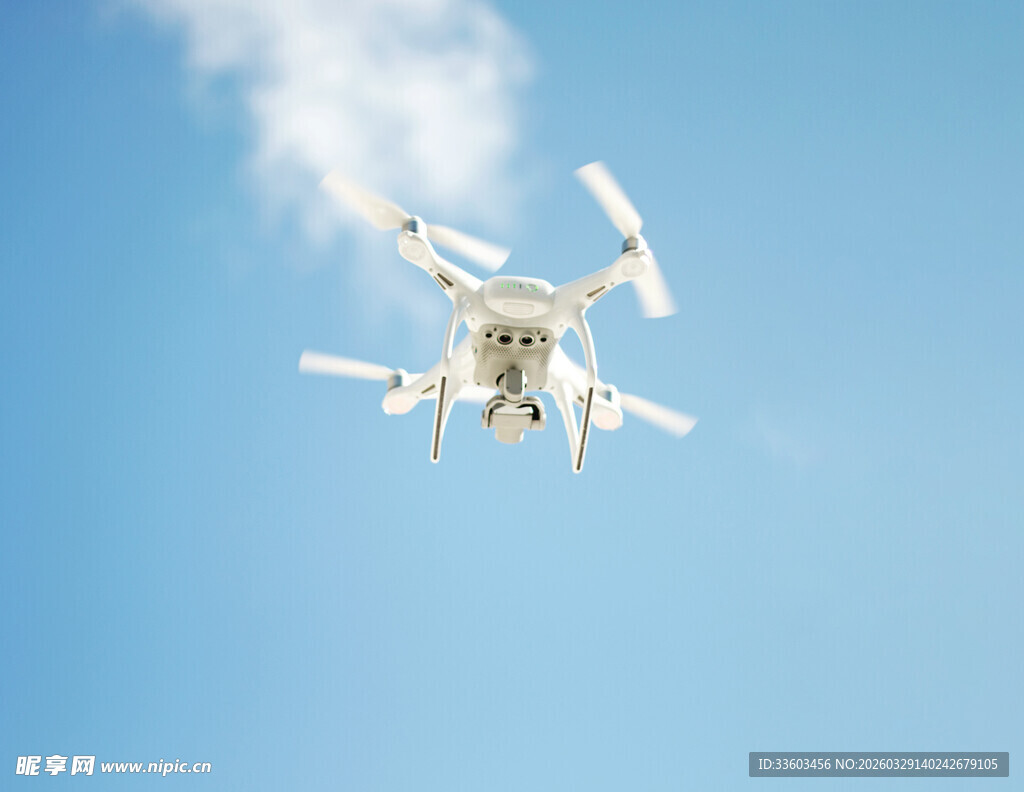 蓝天中飞行的白色无人机