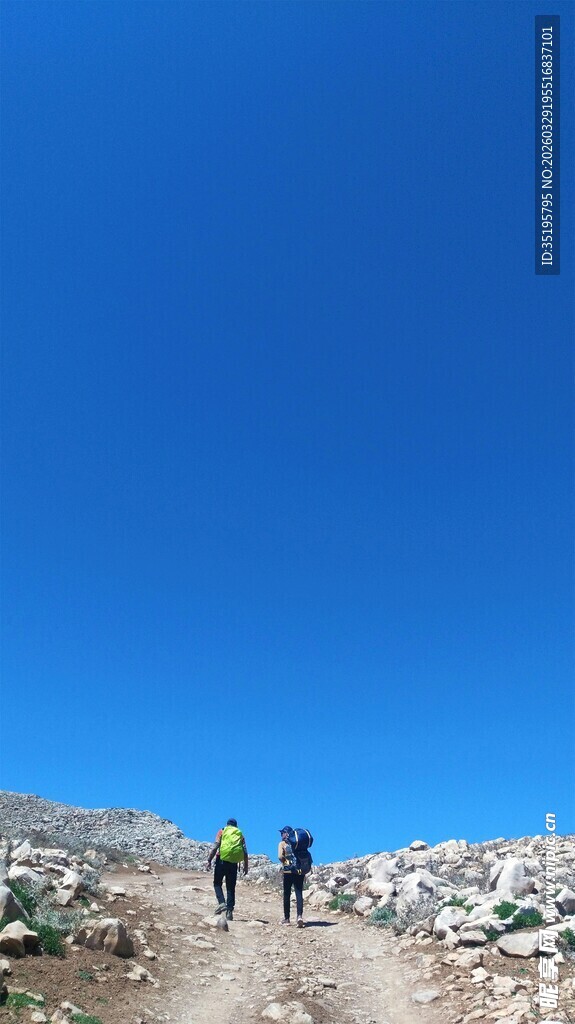 徒步者在蓝天旷野中前行