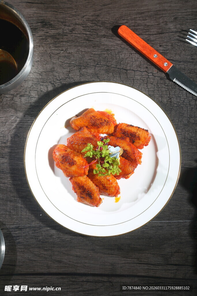 美味烤鸡翅摆于白色盘中