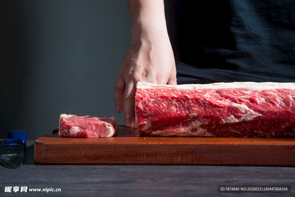 手切新鲜牛肉于案板上