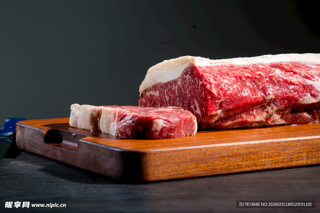 新鲜原切牛排置于木砧板