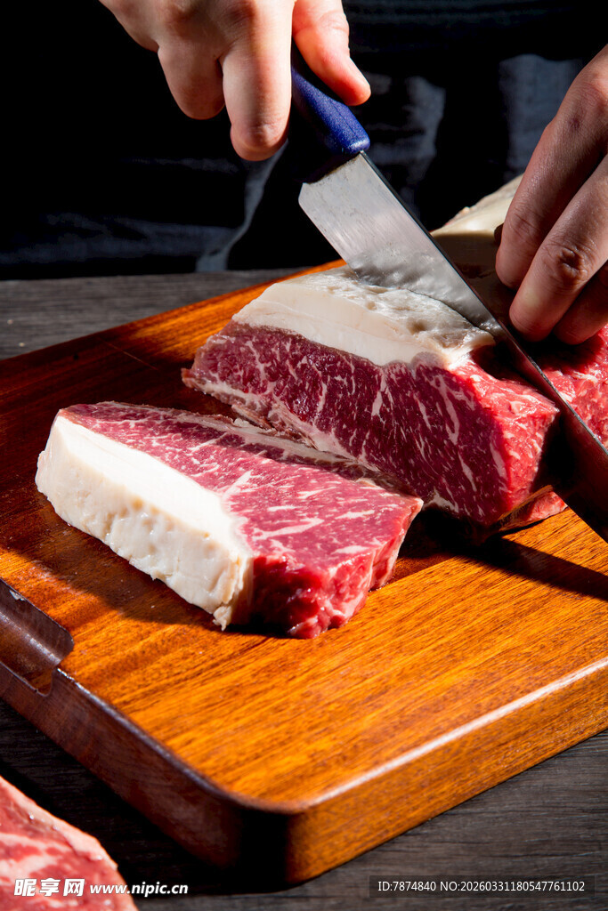 手切新鲜牛肉于砧板上