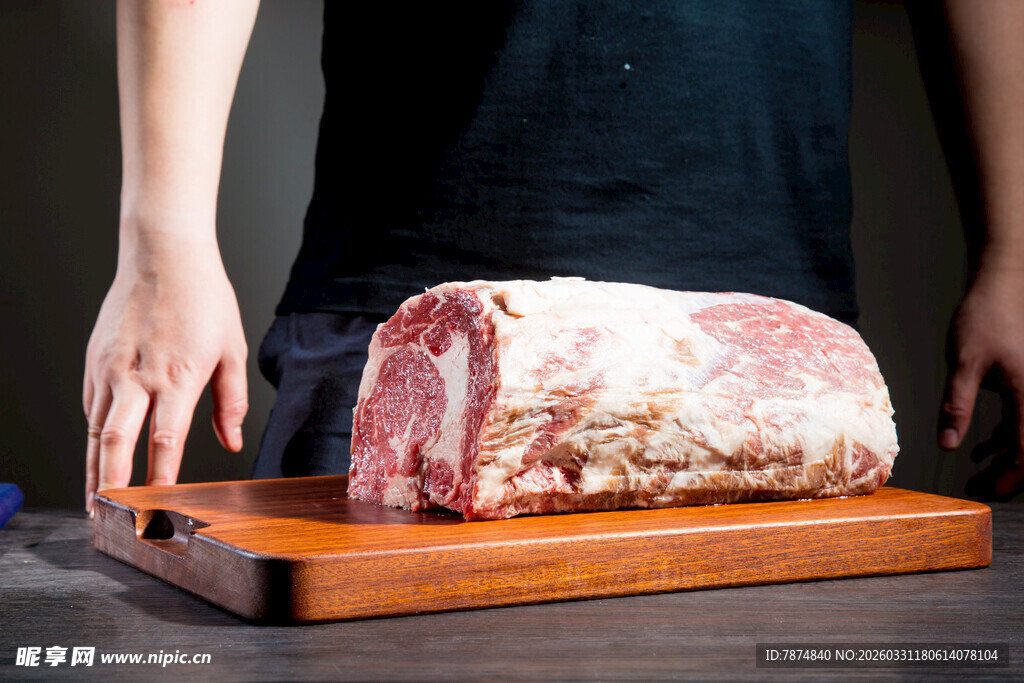 手触大块生猪肉于案板上