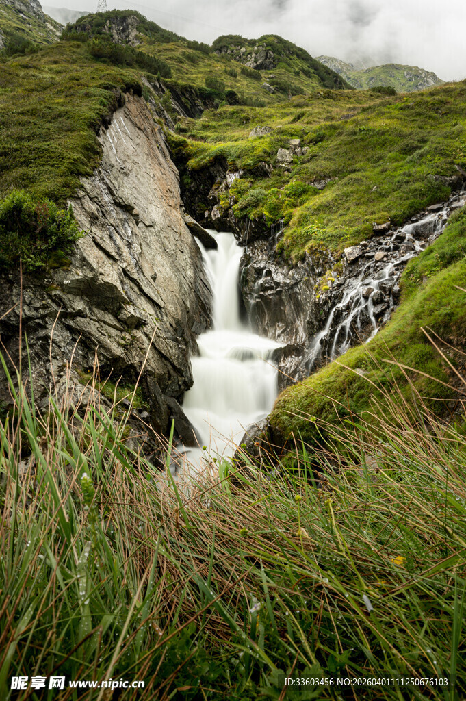 山间瀑布下的葱郁草地