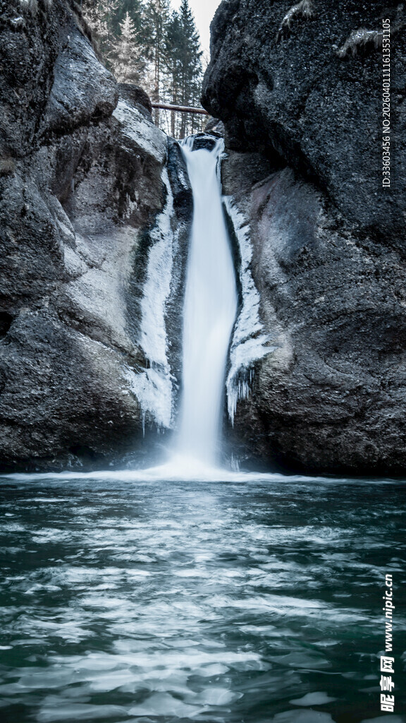 山间飞瀑落入碧绿潭中