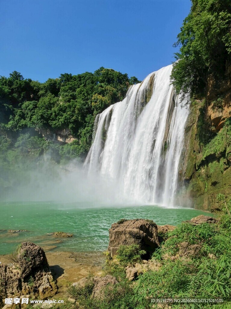壮丽瀑布下的碧绿潭水