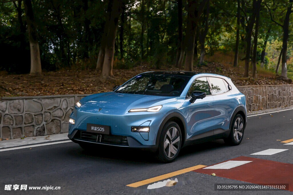 蓝色轿车行驶在林间道路