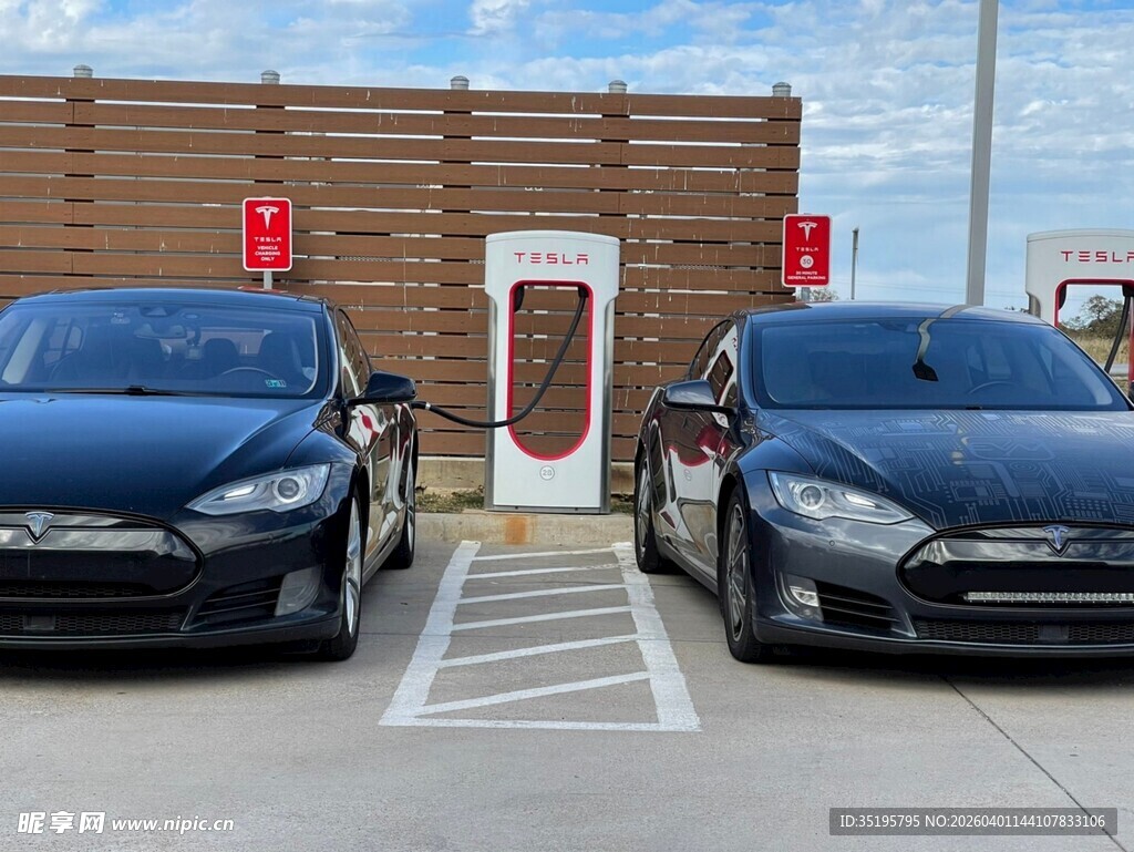 两辆黑色汽车停在充电桩旁