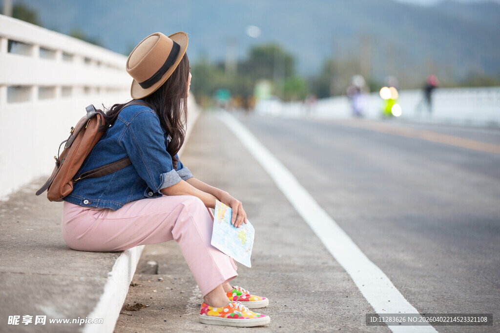 女孩路边休憩背包赏景