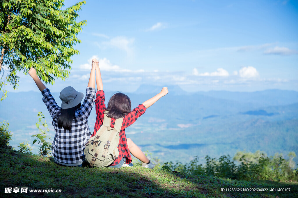 山顶上两人惬意舒展双臂