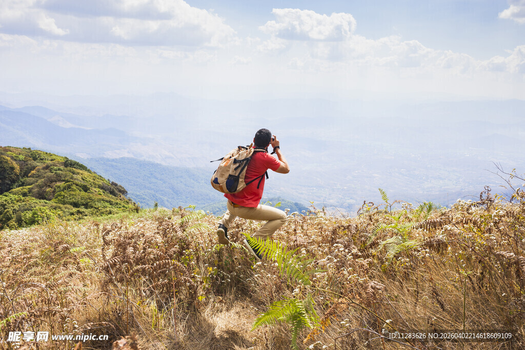 徒步者穿行于山野草地间