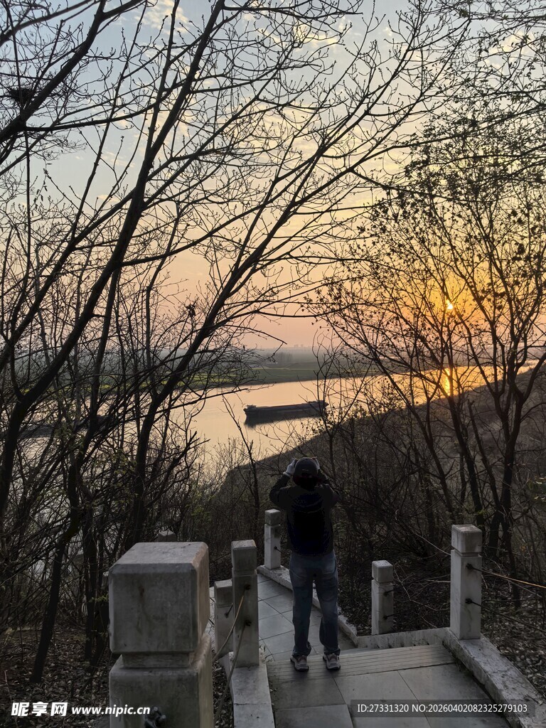 黄昏湖畔步道上的漫步身影