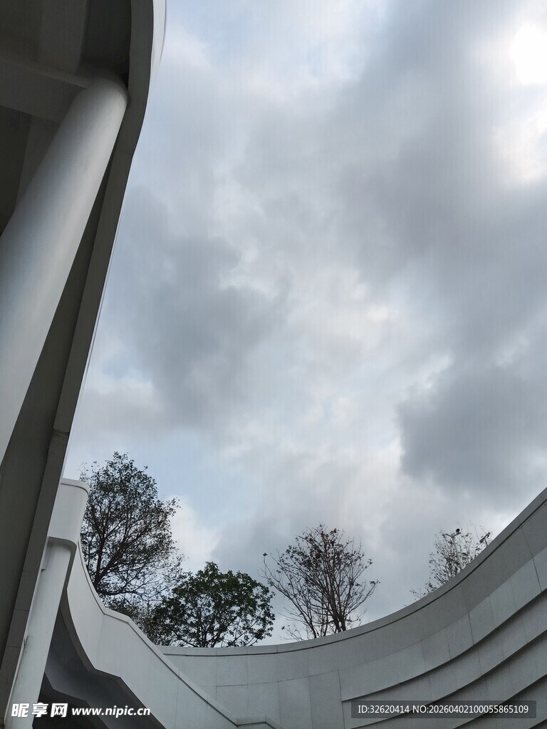 弧形建筑下的天空与树木