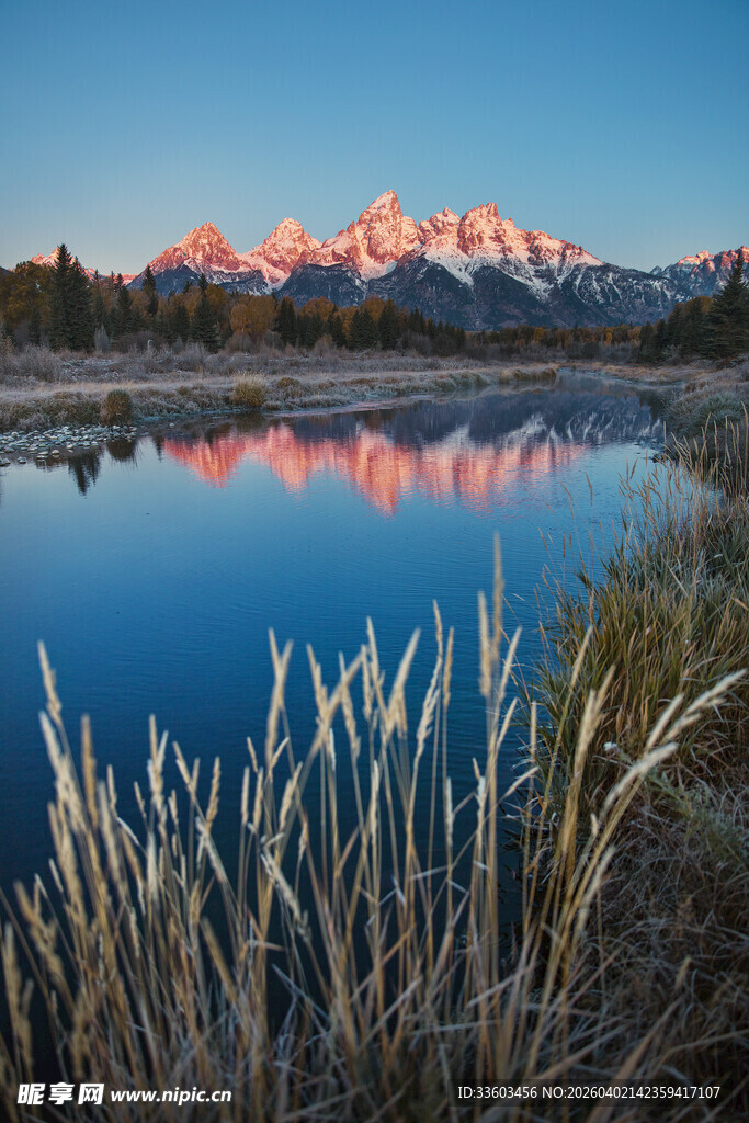 湖畔晨曦中的壮美山峦倒影
