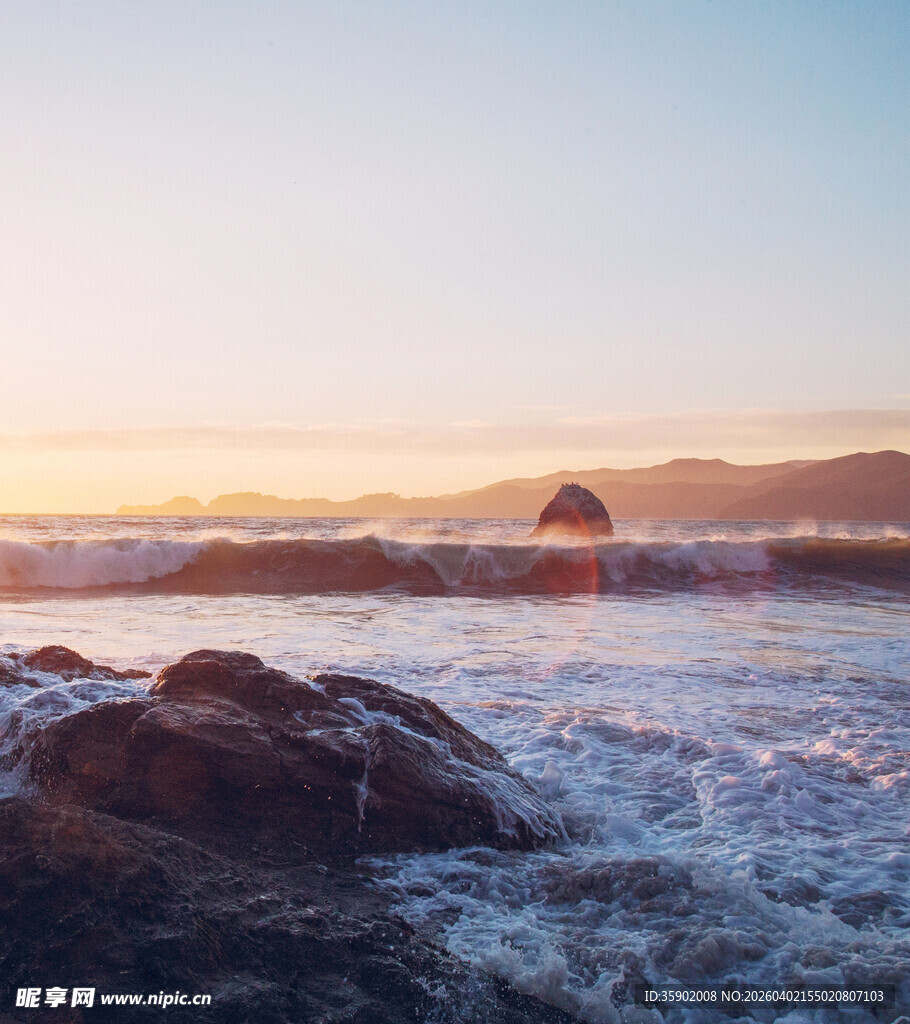 海边日出海浪拍击礁石