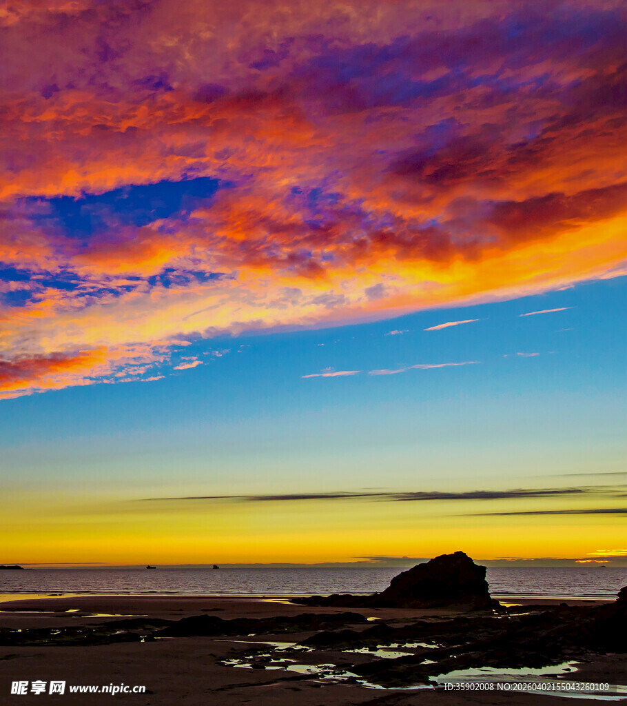 海边绚丽晚霞中的孤岩