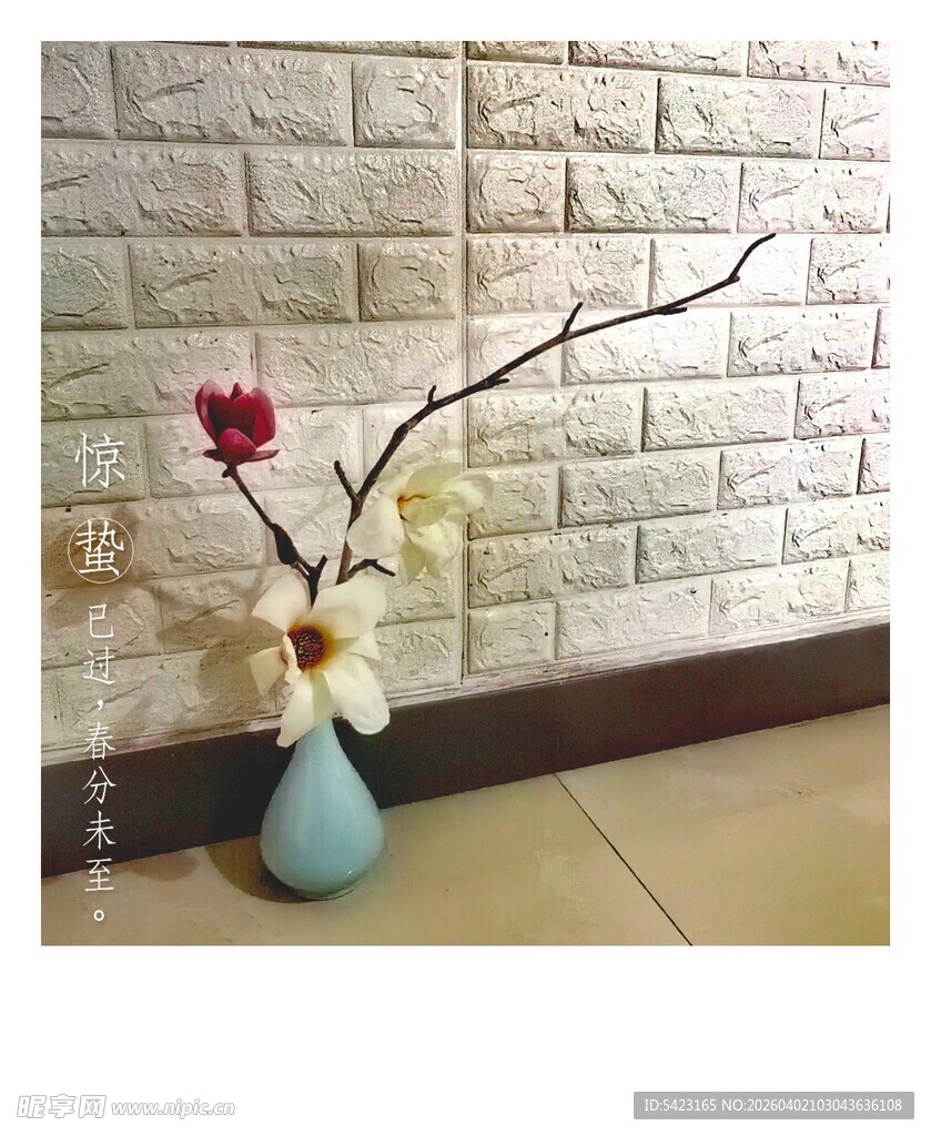 蓝瓶插花于砖墙前的景致