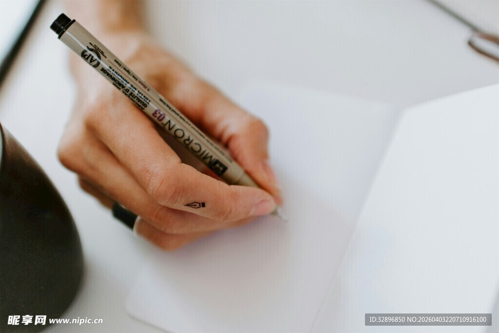 手执笔书写于空白纸张