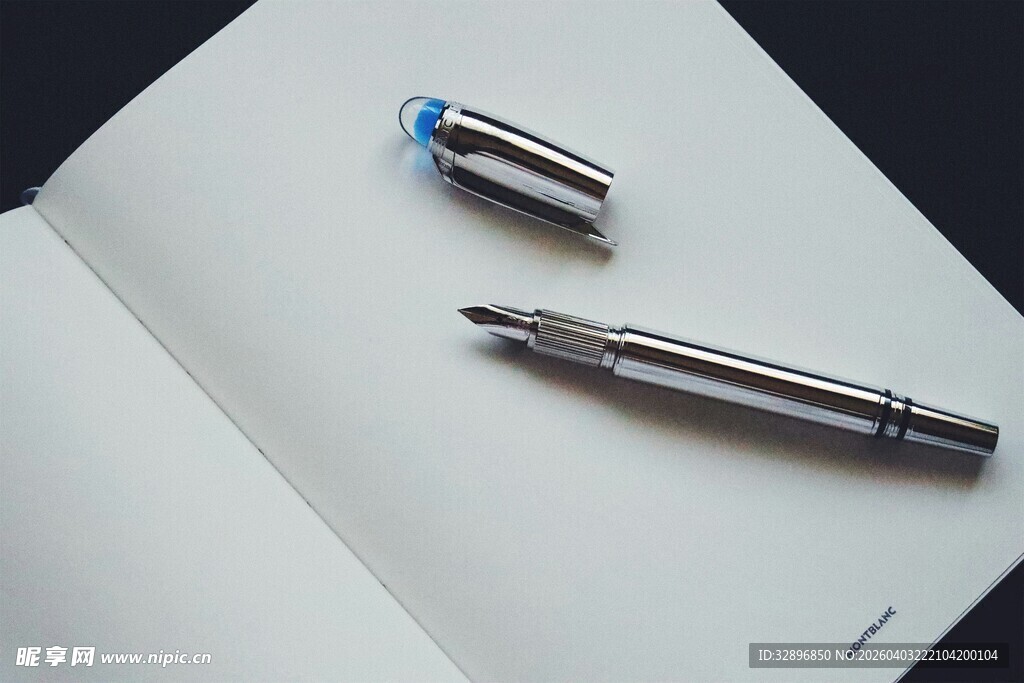 精致钢笔置于打开的本子上