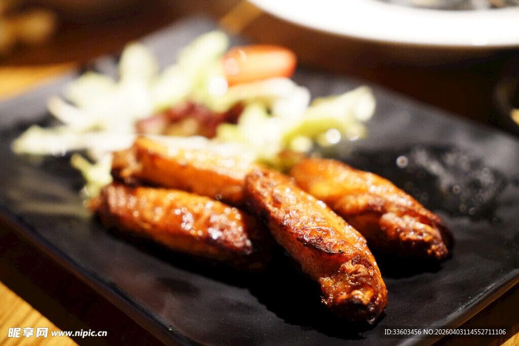 香烤鸡翅摆于黑色盘上