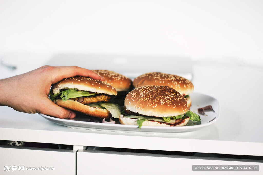 手持美味汉堡与盘中汉堡