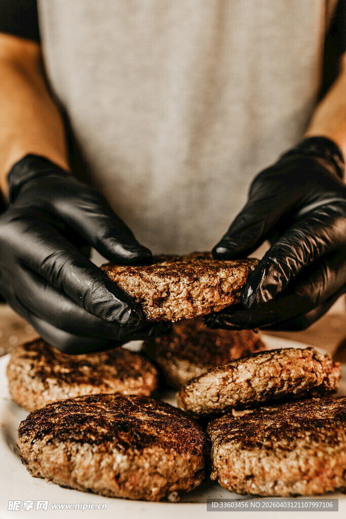 双手戴手套处理多块肉饼