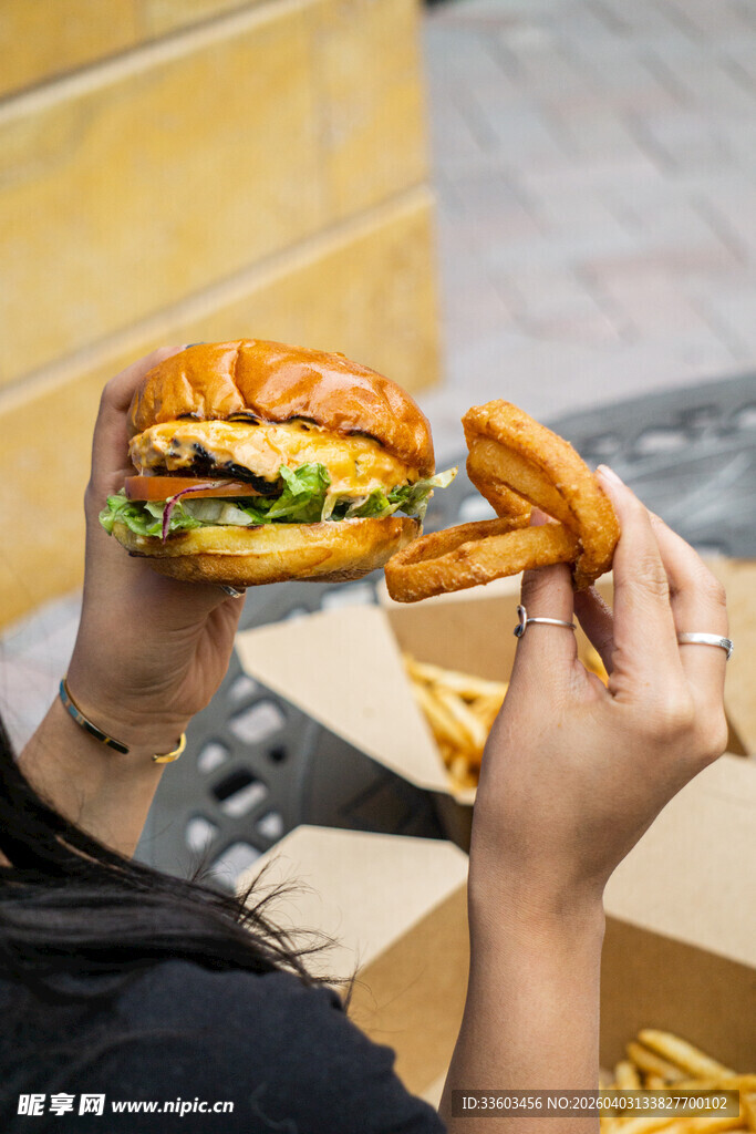 手持美味汉堡与椒盐卷饼