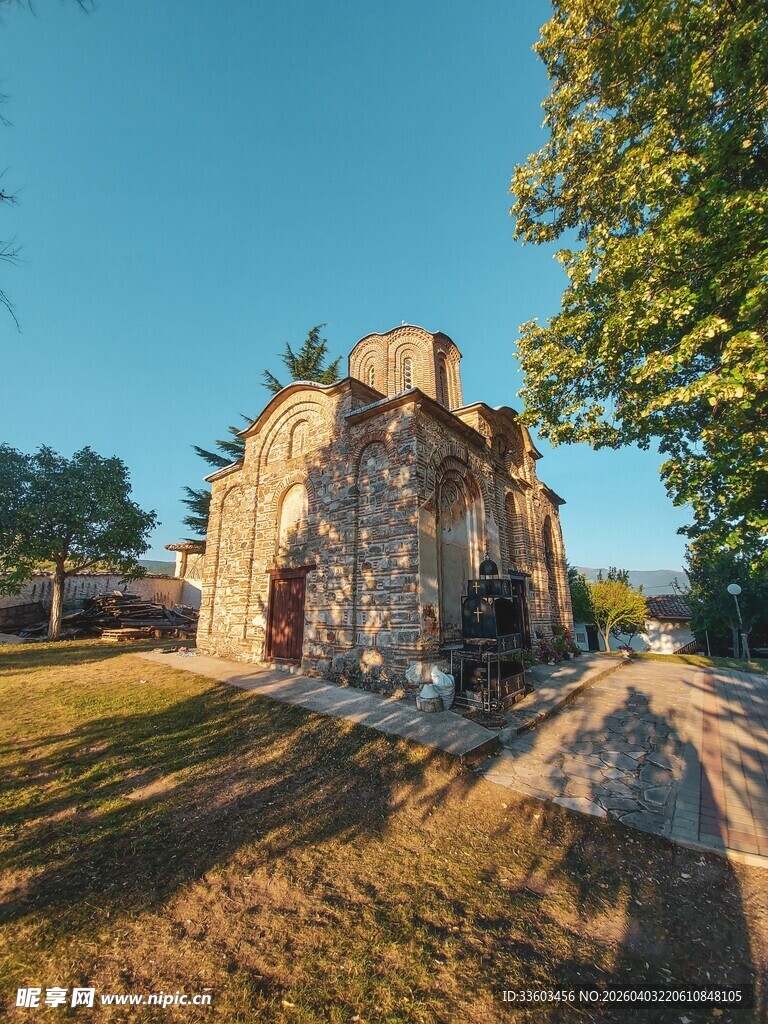 古老石屋立于绿树旁